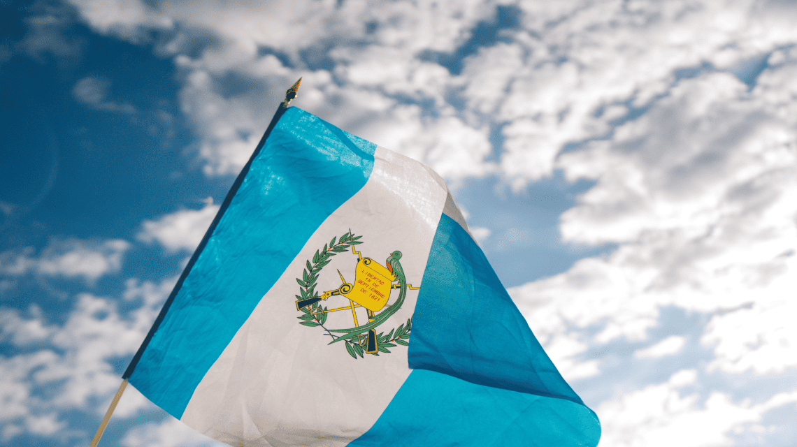 Bandera de Guatemala, al fondo el cielo azul con nubes